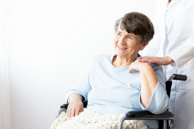 happy grandmother in a wheelchair wuth her caregiver